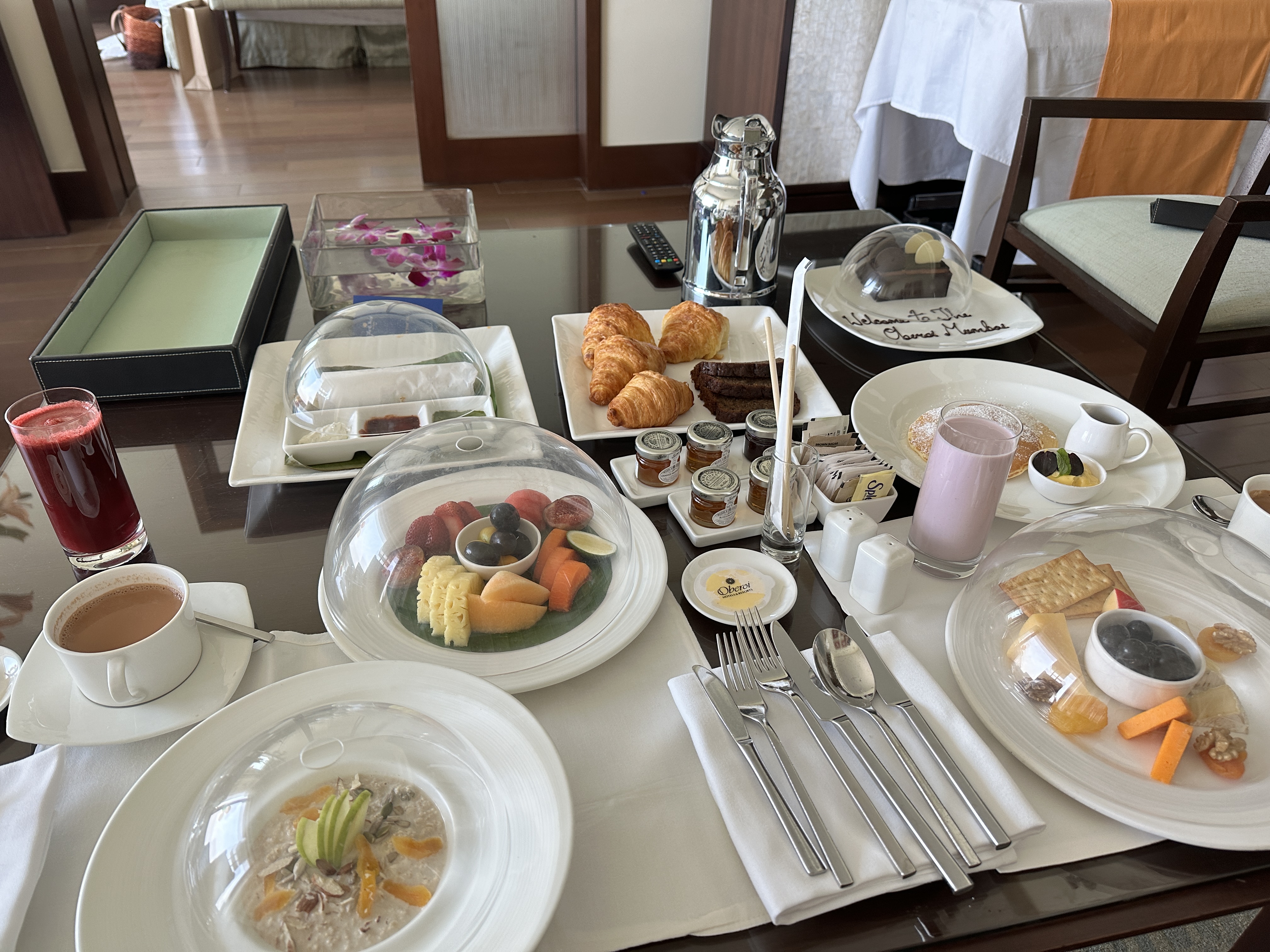 Lavish room service breakfast with fruit, croissants, chai, and juice at The Oberoi Mumbai