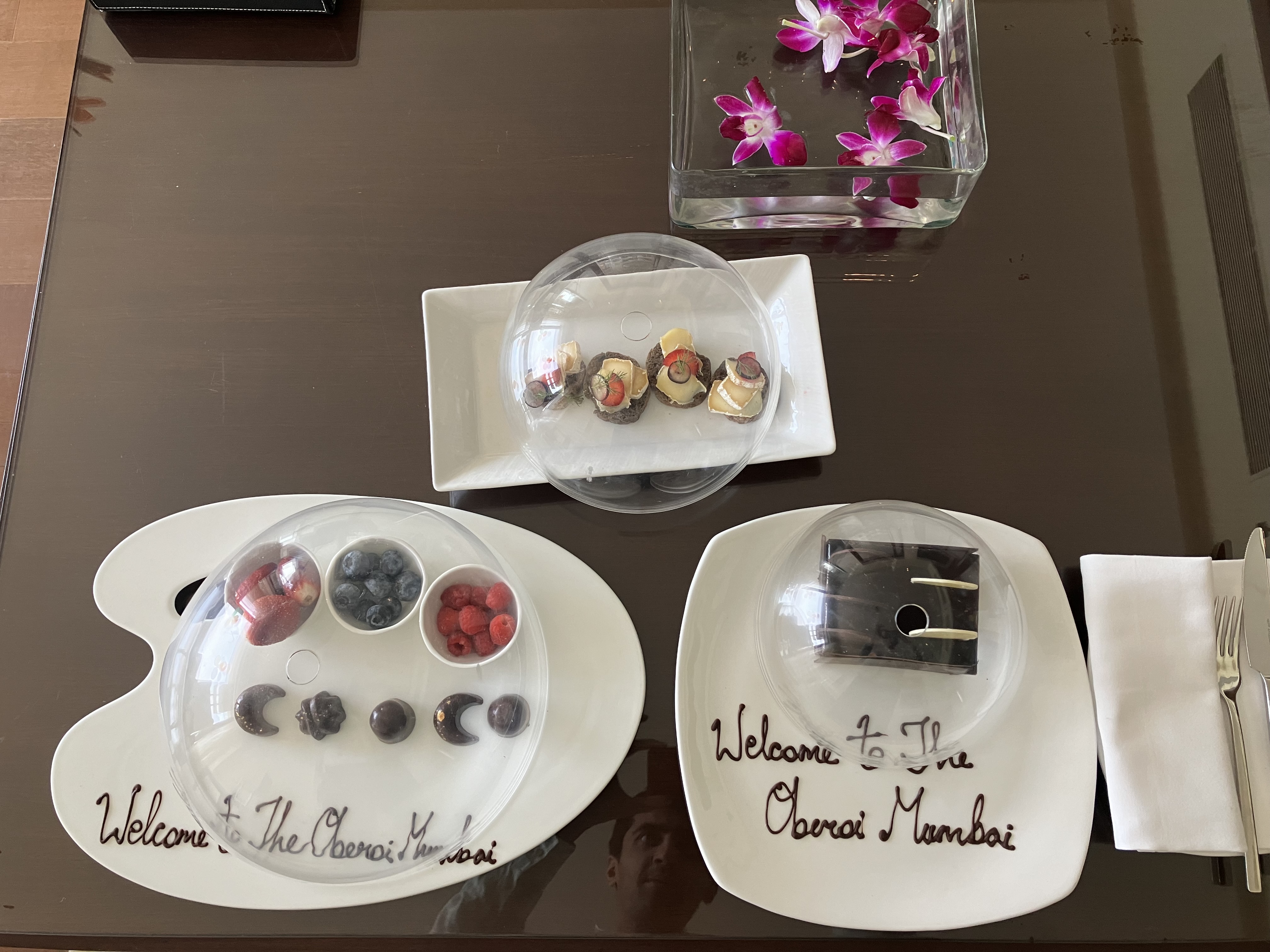Welcome amenities at The Oberoi Mumbai: chocolates, berries, canapés, and orchids